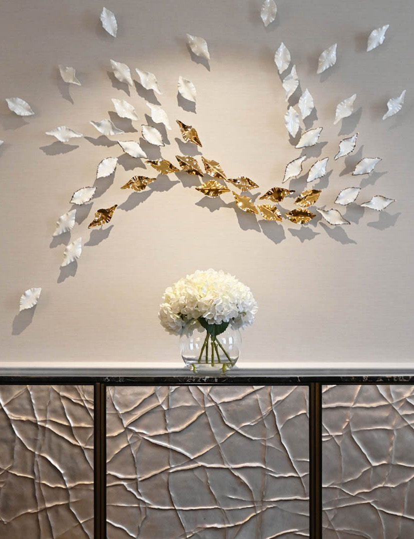 Porcelain leaf wall installation above a bespoke console