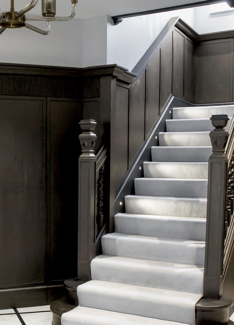 Dark panelled staircase with pale carpet runner