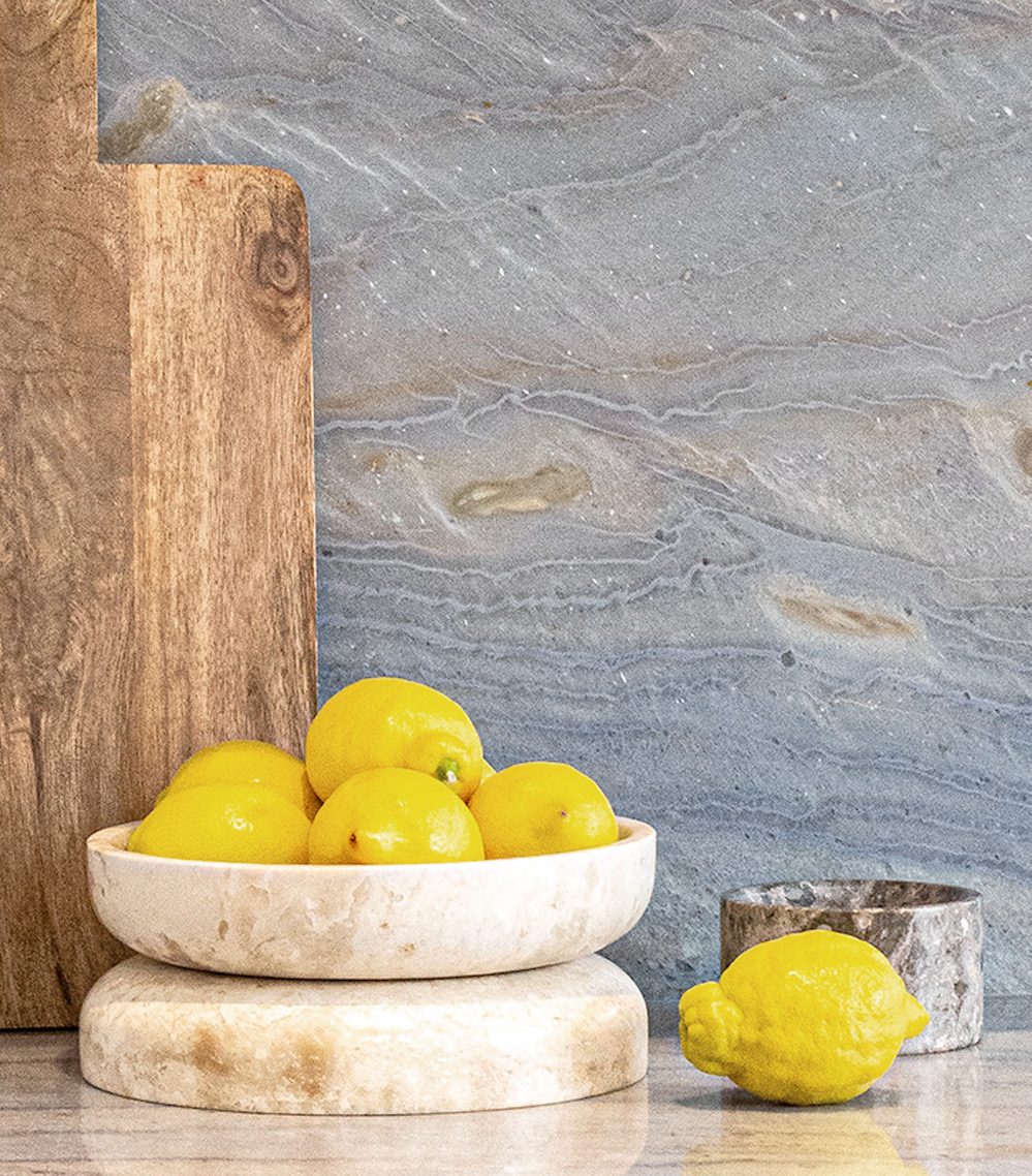 Lemons on a stone surface against a quartzite splashback