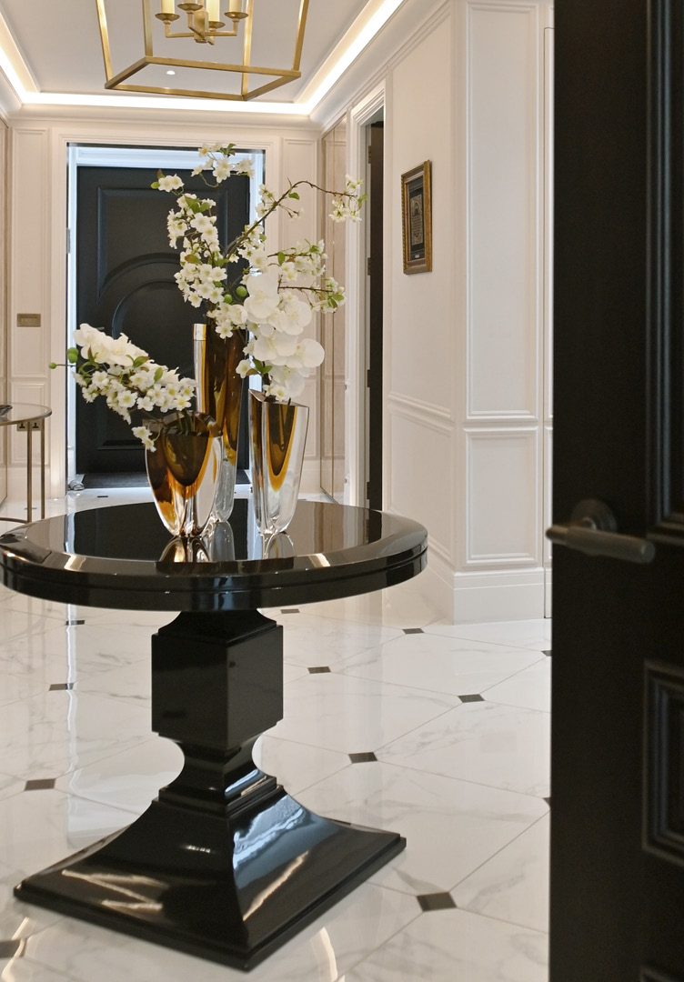 Entryway with black pedestal table and white marble floor