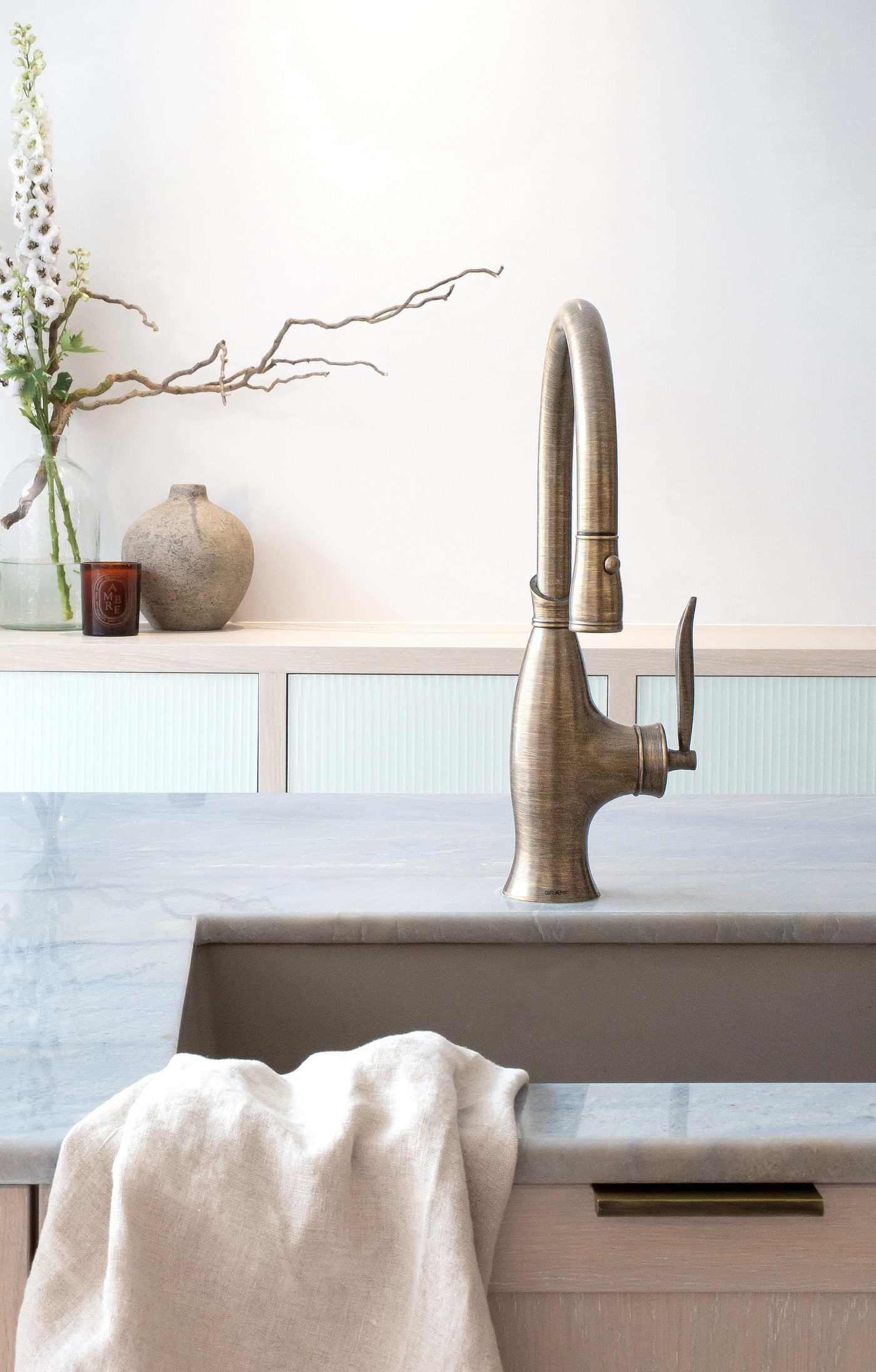 Bronze kitchen tap above a marble countertop