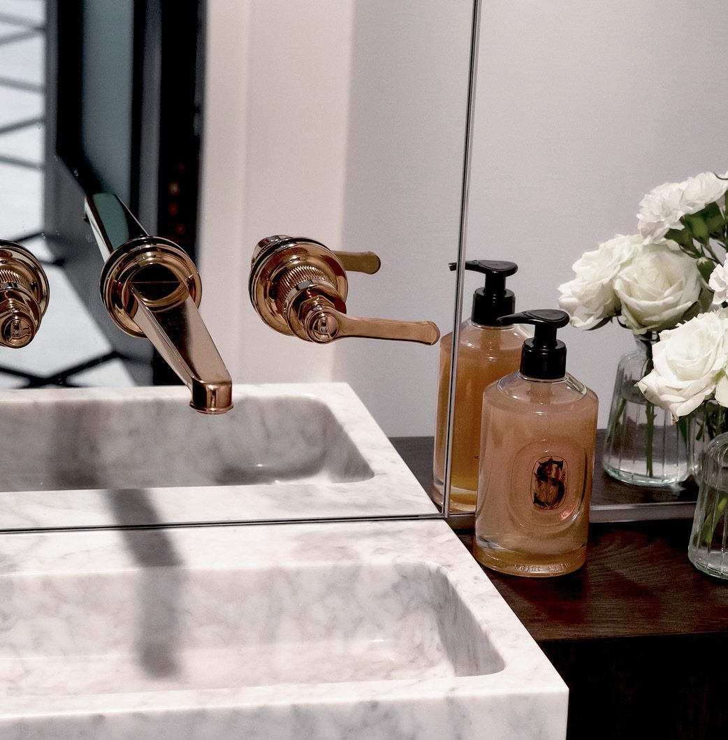 Marble basin with bronze fittings and white roses